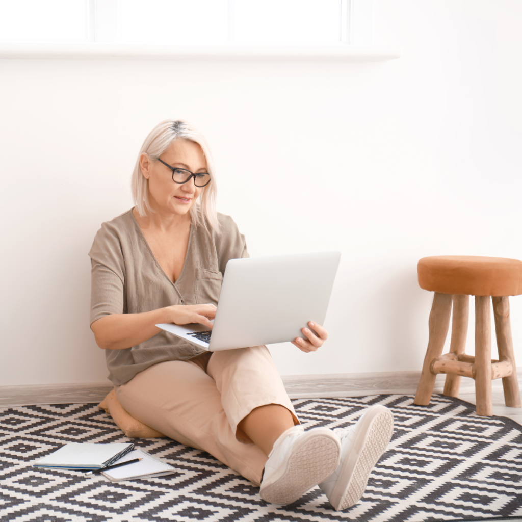 woman at home sitting on the floor using her laptop