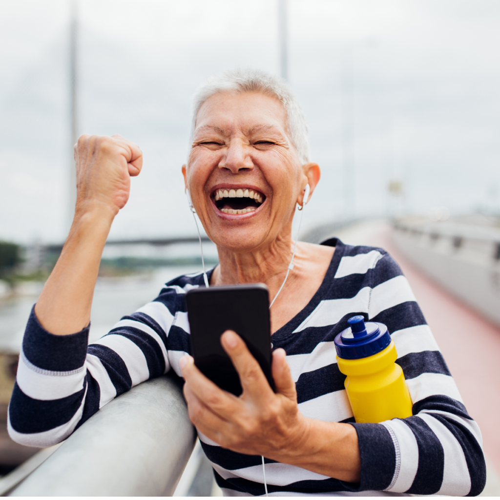 very happy senior woman holding her iphone